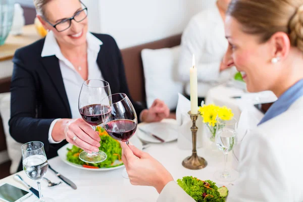 Mulheres no almoço de negócios brindar com vinho — Fotografia de Stock