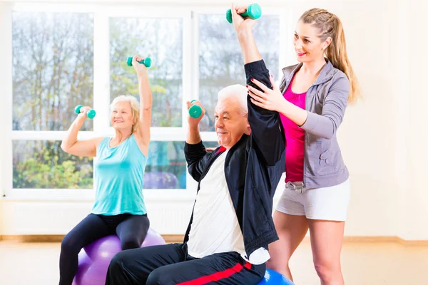 Fisioterapeuta treinando pessoas idosas — Fotografia de Stock