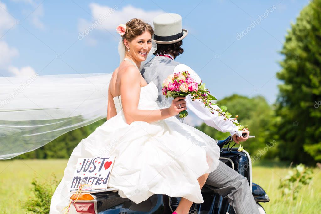 Wedding couple on motor scooter just married