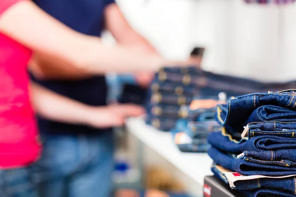 Couple buying blue jeans in shop — Stock Photo, Image