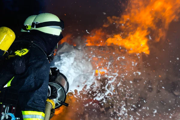 Пожежник - пожежники гасять велике полум'я — стокове фото
