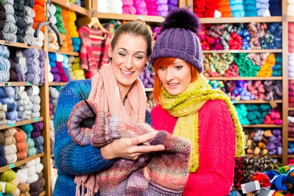 Las mujeres jóvenes en la tienda de punto suéter de compras —  Fotos de Stock