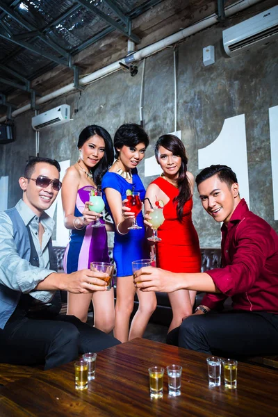 Asian friends drinking cocktails in nightclub — Stock Photo, Image