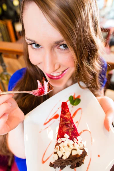 Jovem mulher comendo bolo de frutas no café ou padaria — Fotografia de Stock