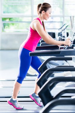 Sportif kız koşu bandında egzersiz yapıyor. 