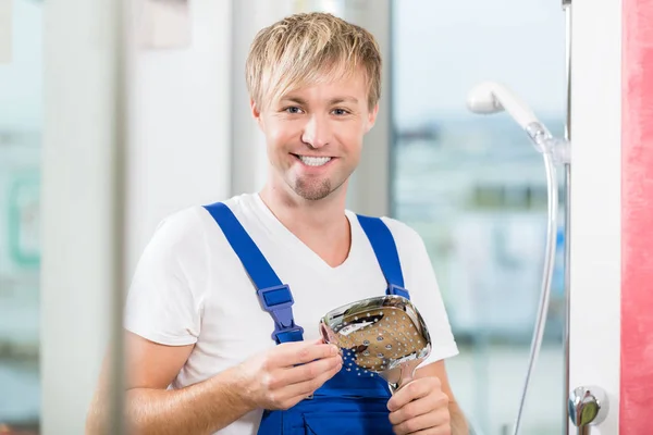 Retrato de un trabajador de mantenimiento alegre sosteniendo un grifo —  Fotos de Stock