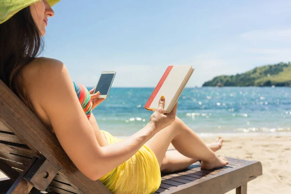 Wanita muda ragu-ragu antara membaca buku dan menghabiskan waktu di internet — Stok Foto