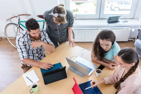 Vista de alto ángulo de cuatro nómadas digitales competentes que comparten ideas — Foto de Stock