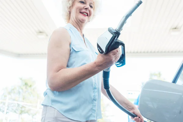 Zbliżenie dłoni starszy kierowca kobieta dozownik gazu — Zdjęcie stockowe