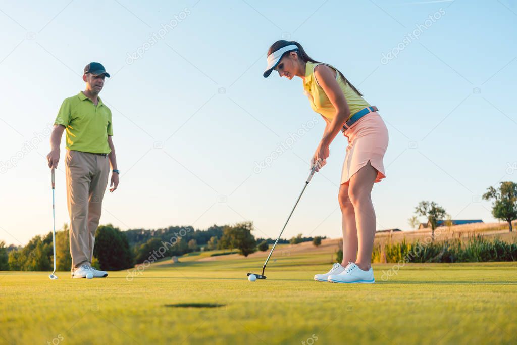 Full length of a woman playing professional golf with her male partner