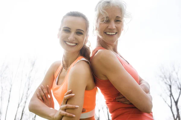 Senior en jonge vrouw doen buiten sport — Stockfoto