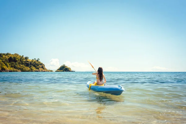 Mujer remando en un kayak en el mar en aguas claras — Foto de Stock