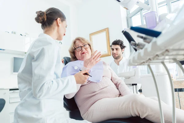 Dentiste et assistant saluant patient aîné — Photo