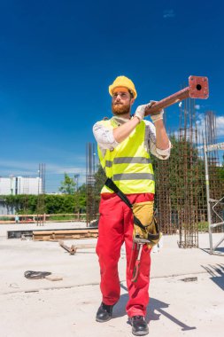 Mavi yakalı işçi ağır metal çubuk çalışmaları sırasında taşıma