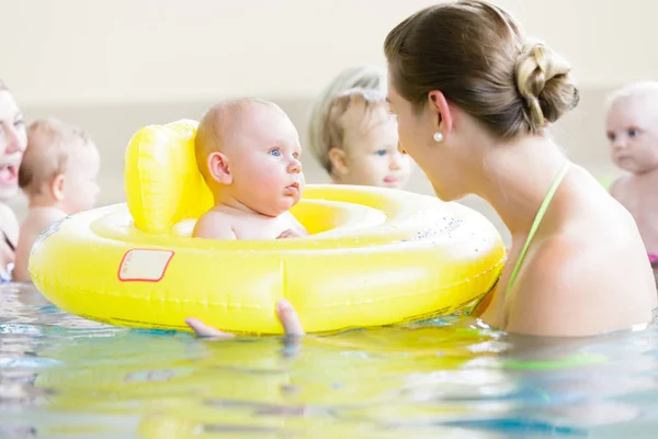 Mothers and kids having fun together playing with toys in pool — Stock Photo, Image