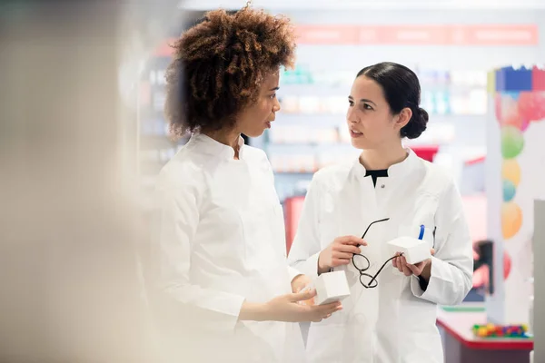 Vista lateral de dos farmacéuticos dedicados en busca de la mejor medicina — Foto de Stock