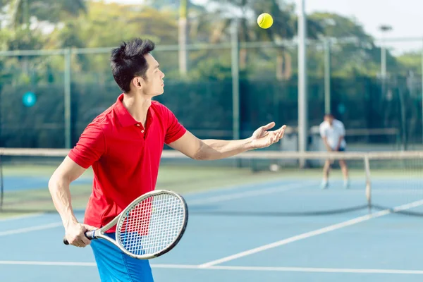 Chinese tennis player ready to hit the ball while serving in a tennis match — Stock Photo, Image