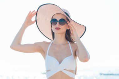 Güneş şapkası ayakta plajda kadınla