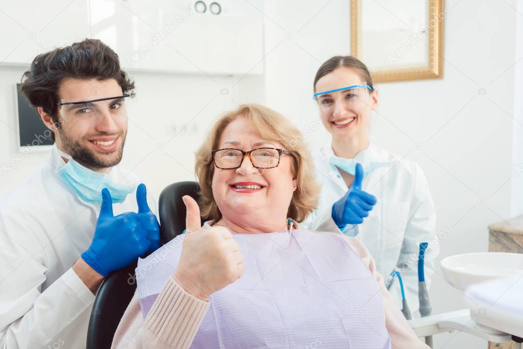 Dentists and patient in surgery being excited