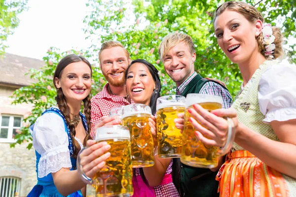 Amigos se divertindo no jardim da cerveja enquanto óculos clinking — Fotografia de Stock