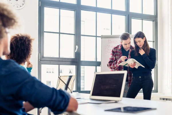 Estudiantes compartiendo ideas y opiniones mientras hacen una lluvia de ideas durante la clase — Foto de Stock