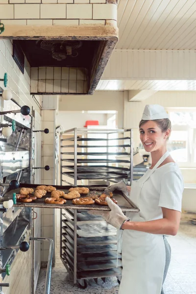 Baker mujer conseguir productos de panadería fuera del horno —  Fotos de Stock