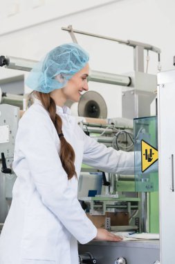 Kadın üretim mühendisi bir endüstriyel makine ayarlarını yapma
