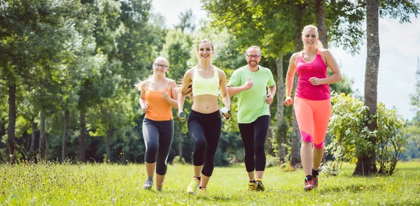 Family with personal Fitness Trainer jogging — Stock Photo, Image