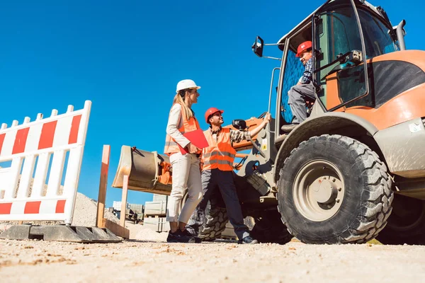 Ingeniero civil y discusión de los trabajadores en la construcción de carreteras — Foto de Stock