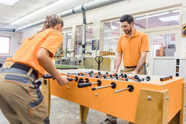 Zwei Tischler spielen in der Arbeitspause Tischkicker — Stockfoto