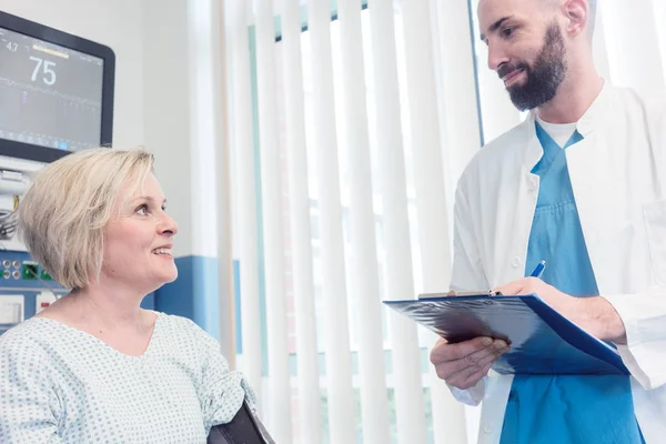 Arts in gesprek met de patiënt in herstel kamer van ziekenhuis — Stockfoto