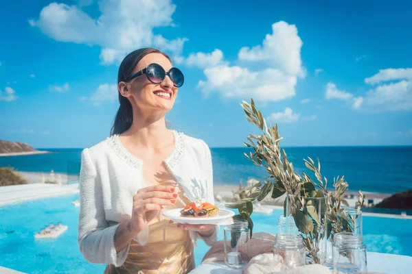 Kvinna som njuter av god mat på beach house party — Stockfoto