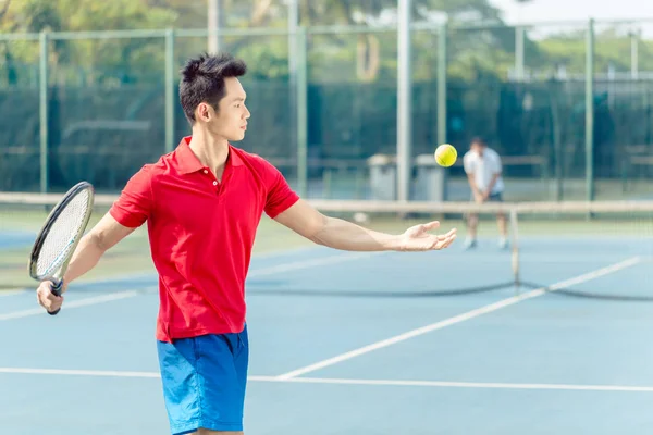 Chinesischer Tennisspieler bereit, den Ball beim Aufschlag zu schlagen — Stockfoto