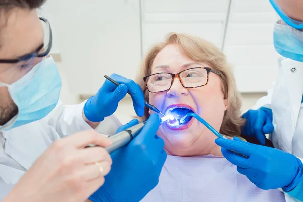 Dentistas endurecimento coroa de toot com luz UV — Fotografia de Stock