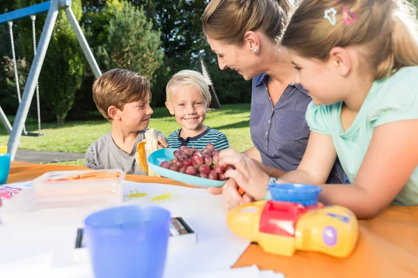 Mamá pintando cuadros con sus hijos durante el almuerzo — Foto de Stock