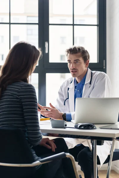 Jeune médecin dévoué à l'écoute avec attention à son patient — Photo