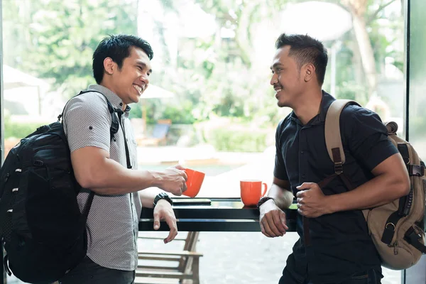 Boční pohled dvou veselých mladých mužů, mluví a pití kávy — Stock fotografie