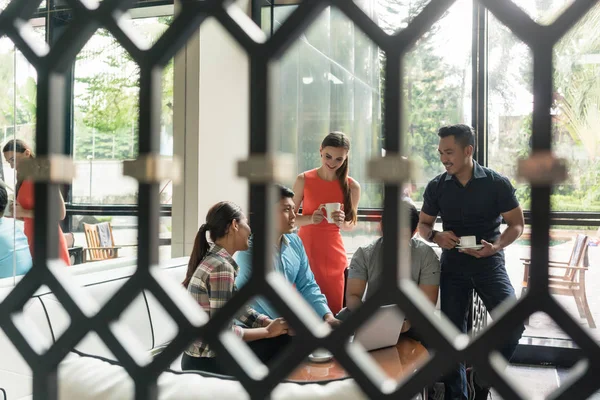 Grupo de empleados alegres tomando café en el salón —  Fotos de Stock