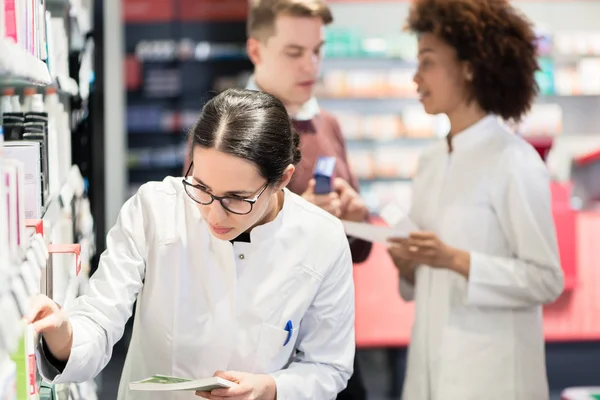 Retrato de uma fêmea experiente farmacêutico leitura pacote indicações — Fotografia de Stock