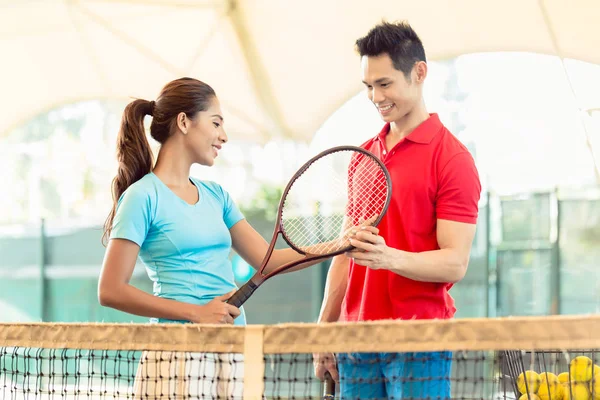 Tennis instructeur onderwijs een beginnende speler de juiste grip — Stockfoto