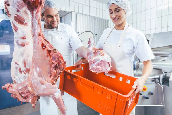 Equipe de açougueiros que trabalham com carne no açougue — Fotografia de Stock