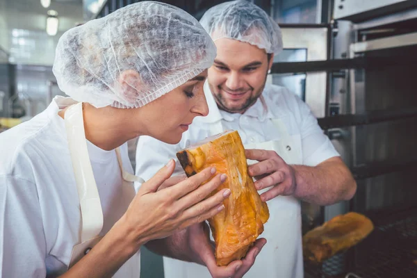 Carniceros comprobando la calidad de la carne ahumada — Foto de Stock