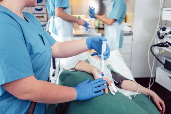 Enfermeira dando anestesia ao paciente à espera de endoscopia — Fotografia de Stock