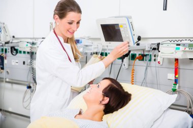Doktor yoğun tıbbi bakım kadın hastanın sonuçlarını denetleme