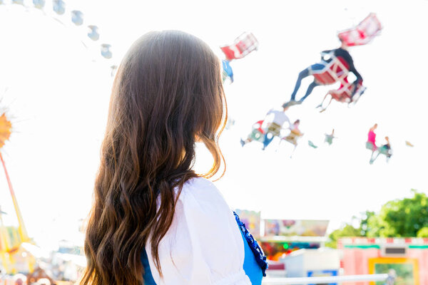 woman wearing dirndl standing in front of ferris wheel