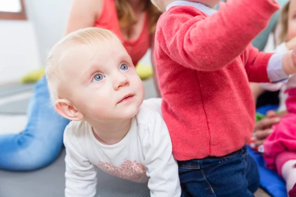 Portret van een schattige blonde babymeisje spelen met kleurrijke speelgoed — Stockfoto