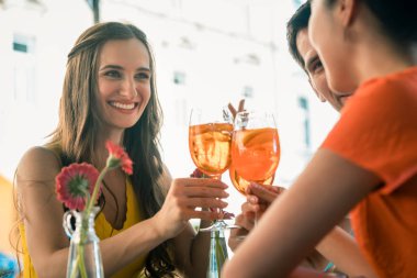Güzel kadın ve serinletici bir içki ile toasting en iyi arkadaşları