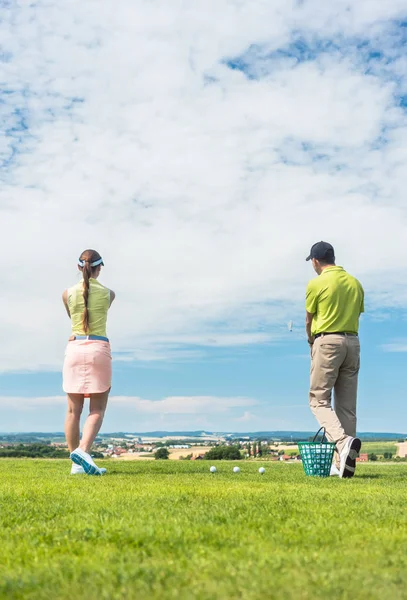 Mujer joven practicando el movimiento correcto durante la clase de golf —  Fotos de Stock