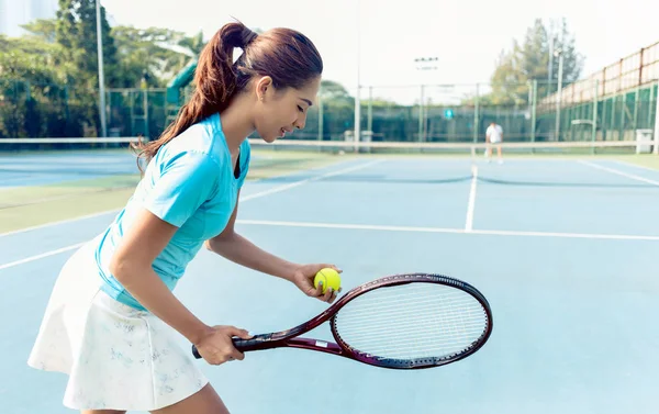Jogadora profissional sorrindo enquanto serve durante o jogo de tênis — Fotografia de Stock