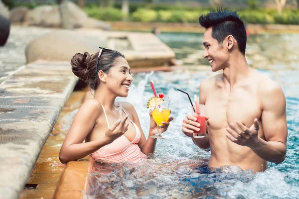 Νεαρός άνδρας φλερτάρει με μια ελκυστική γυναίκα σε ένα μοντέρνο πισίνα — Φωτογραφία Αρχείου